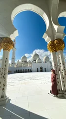 Fotobehang The Sheik Zahed Grand Mosque in Abu Dhabi with a beautiful women in front © Daniel