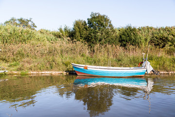 Una barca in un canale sul mare, Latina, Italia