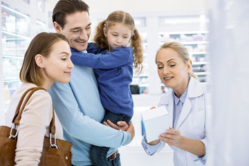Fototapeta premium Blonde professional female pharmacist aiding young family