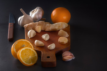 Ginger, garlic and lemon - a means to protect against viral infection and colds on a dark table. Low key. Copy space