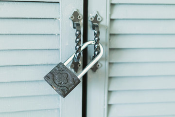 metal lock on the handles of wooden doors with blue bars