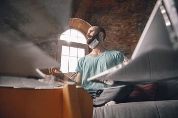 Paperwork. Young man doing yoga at home while being quarantine and freelance online working. Remote office, isolated. Concept of healthy lifestyle, wellness, being safe while coronavirus pandemic.