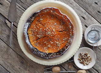 Pumpkin Background. Baked pumpkin sprinkled with ground walnuts, on a wooden ancient background with ingredients. Place for text.