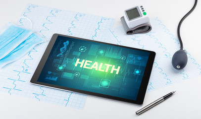 Tablet pc and medical stuff with HEALTH inscription, prevention concept