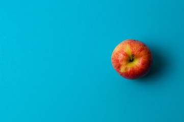 Apple on a blue background. Healthy eating, calorie count and weight loss concept
