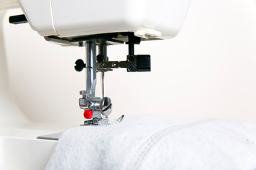 Sewing machine, white fabric, light background
