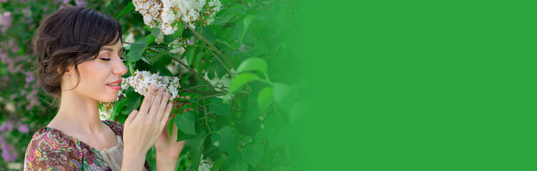 Fototapeta premium Beautiful young girl is surrounded by flowers of Lilac. Cosmetic products for skin care. Health, beauty, cosmetics concept banner