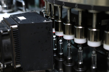 Pharmaceutical industry. Production Line. Machine conveyor with glass bottles, ampoules in a factory. Fill bottles and ampoules for solid particles in liquid and container defects. Pharmaceutical