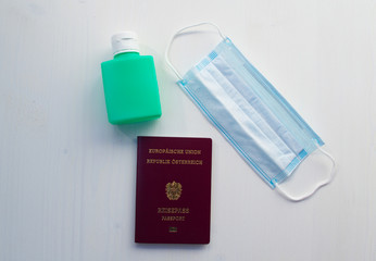 Austrian passport, protective mask and antiseptic on a white background.