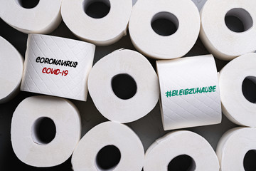 toilet paper rolls with message COVID-19 and German message for #STAYATHOME