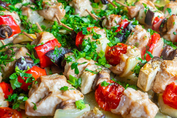 Slices of chicken, eggplant, tomato, sweet peppers and mushrooms are strung on wooden skewers and fried until rosy. Delicious delicacy with freshly chopped cilantro, parsley and green onions.