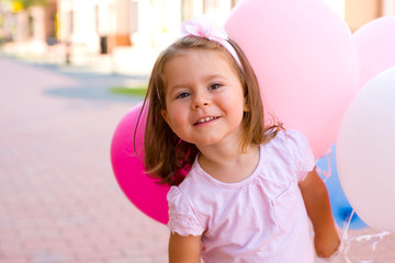 horizontal closeup portrait of a pretty happy girl with balloons