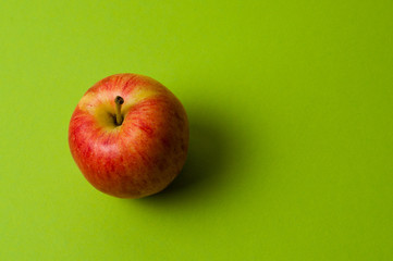 Apple on green background. Healthy eating, calorie count and weight loss concept