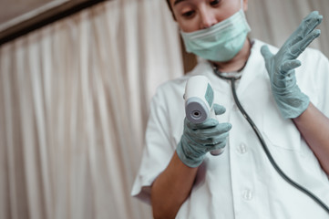 Doctor check your body temperature using infrared forehead thermometer at hospital for Corona...