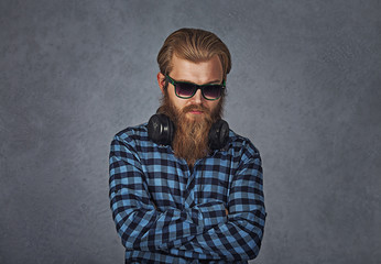 handsome young man confident student, entrepreneur, arms crossed folded on grey