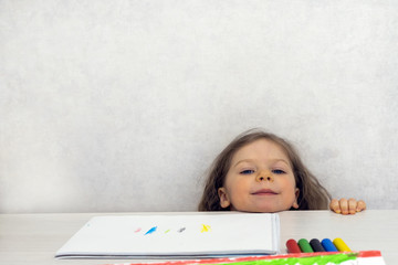 A three-year-old put her head on the drawing table