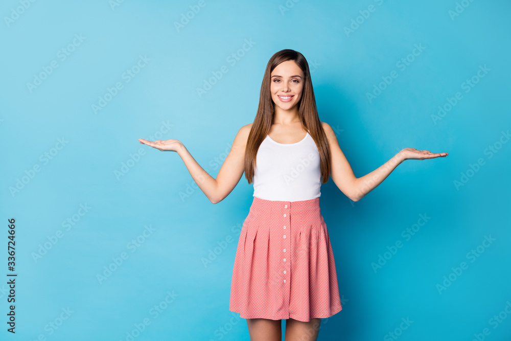 Sticker Portrait of positive cheerful girl promoter hold hand display advert promotion wear good look singlet isolated over blue color background