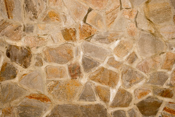 Texture of a wall made of masonry of large stones on concrete. External part of the building.