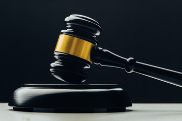 Judge's gavel with gold metal on a black table. Concept of law