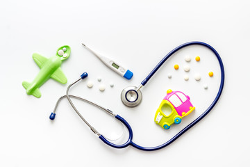 Flu treatment for children. Pills, thermometer, stethoscope and toys on white background top view