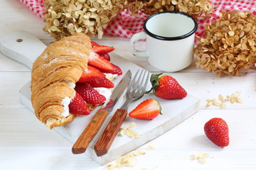 Croissant with strawberries and ricotta cheese on a white background