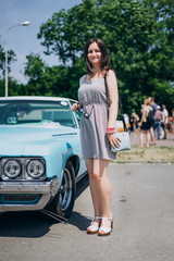 Fototapeta na wymiar Beautiful girl near a blue muscle car