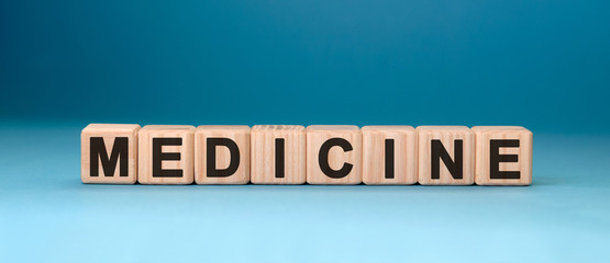 MEDICINE word cube on a blue background. Medical concept.