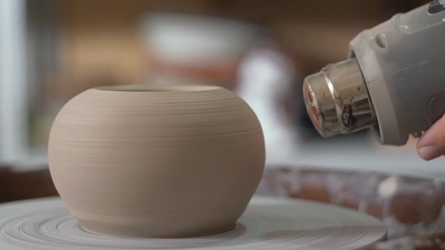 Potter dry clay vase Hairdryer. Average plan. Hot air. The intermediate stage of the work of the Potter