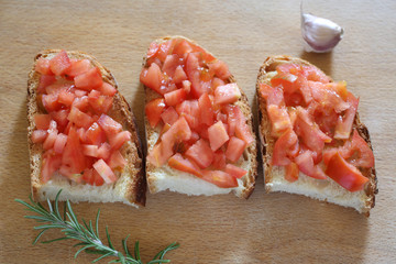 traditional italian bruschetta made with brad and tomato rest on a wooden chopping board