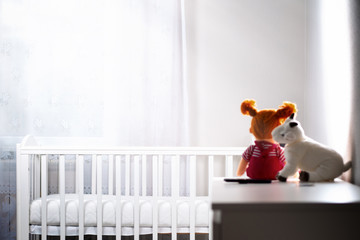 Children's white room with an empty cradle and toys on the dresser. Copy space. Horizontal. The...