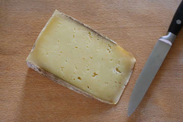 slice of seasoned cheese rest on a wooden tabel with copy space for your text