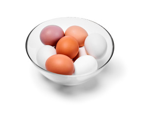 eggs of different colors from white to brown in a glass bowl, isolated on a white background