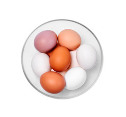 eggs of different colors from white to brown in a glass bowl, isolated on a white background