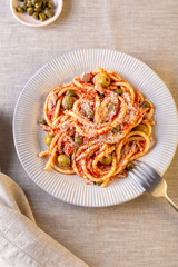 Bucattini pasta with tuna, olives and capers in marinara sauce