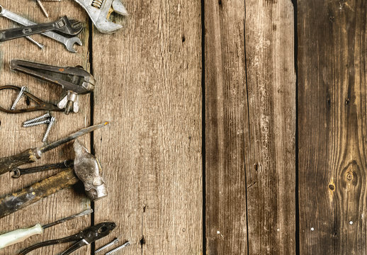 A set of metal tools in the workshop on an old rustic wooden background.concept.Father's day or labor day holiday.A greeting card or banner for your store or website.Copyspace.Mock up.Flat lay
