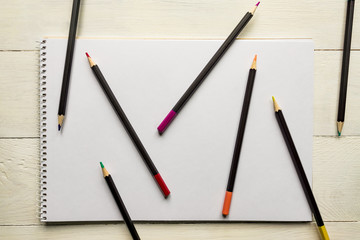 colour pencils on blank white album paper. Top view. school and office supplies