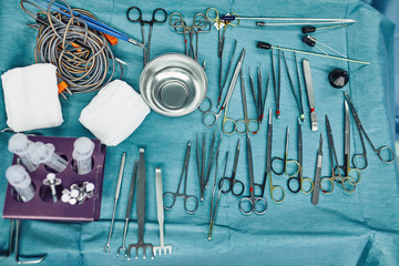 Surgical instruments in the operating room, laid out on a sterile table on a special blue tissue. The concept of medecine, surgery, sterile area. Plastic surgery. Selective focus.