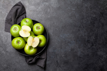 Ripe green apple fruits on dark stone table
