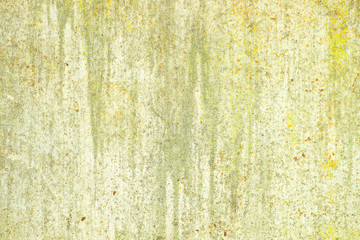 Concrete wall painted in yellow-green. Aged and weathered painted wall texture.