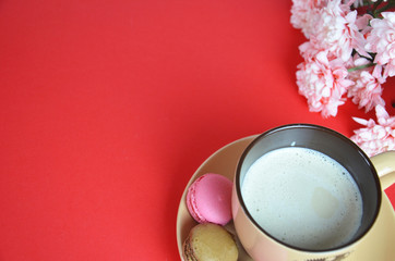 beige cup cappuccino beautiful white-pink aster flowers on a red background. good morning. greeting card. view from above. save space cookies macarune Mothers day or Womens day