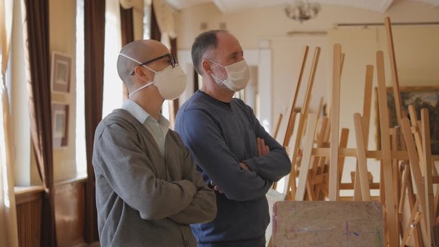 Two people in medical masks standing in the gallery look at the exhibit