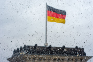 Raindrops on the window with German flag in soft focus in the background
