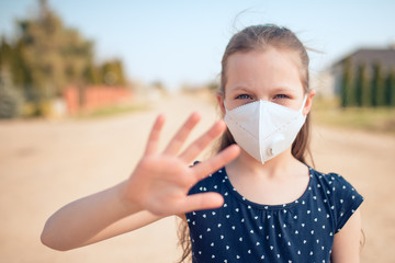 Coronavirus and air pollution concept. Little Caucasian girl wearing face mask for protection and...
