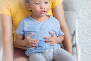 Little boy sick, suffering from stomachache, painful disease concept. little boy with stomach ache, child holding his hands on his belly. Stomach ache child stock image.