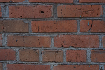 Brick masonry of bright red color in the form of a wall