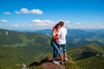 Naklejka premium Happy couple hugging in the top of mountain.