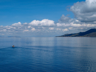 View of lake Titicaca with boat and island, Peru