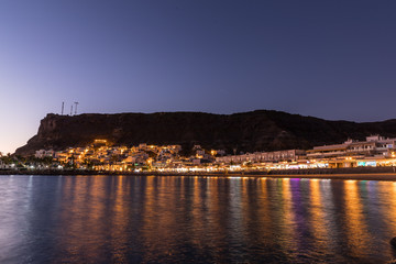 Obraz premium Mogan beach during sunset with the city lit up by street lights and freshly lit streets of the grand canary island valley