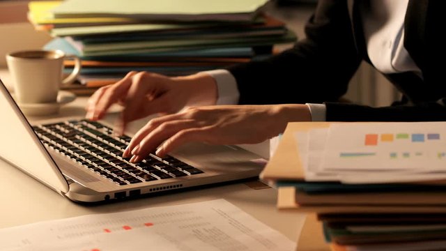 Close up of an overworked executive hands working in the night at office