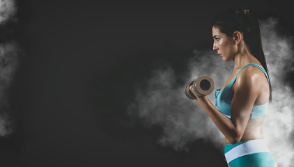 Sporty muscular woman with dumbbell. Matte effect